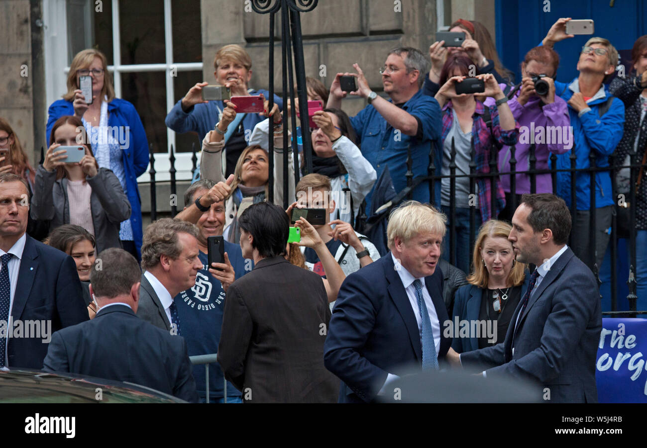 El Bute House, Edimburgo, Escocia, Reino Unido. El 28 de julio de 2019. El Primer Ministro Boris Johnson da un lado mira el jeering abuchear y multitudes como él llega a satisfacer en primer Ministro de Escocia, Nicola Sturgeon en el Bute House. La multitud detrás son trabajadores de oficina tratando de echar un vistazo y fotografías en teléfonos móviles. Crédito: Arco Blanco/Alamy Live News Foto de stock