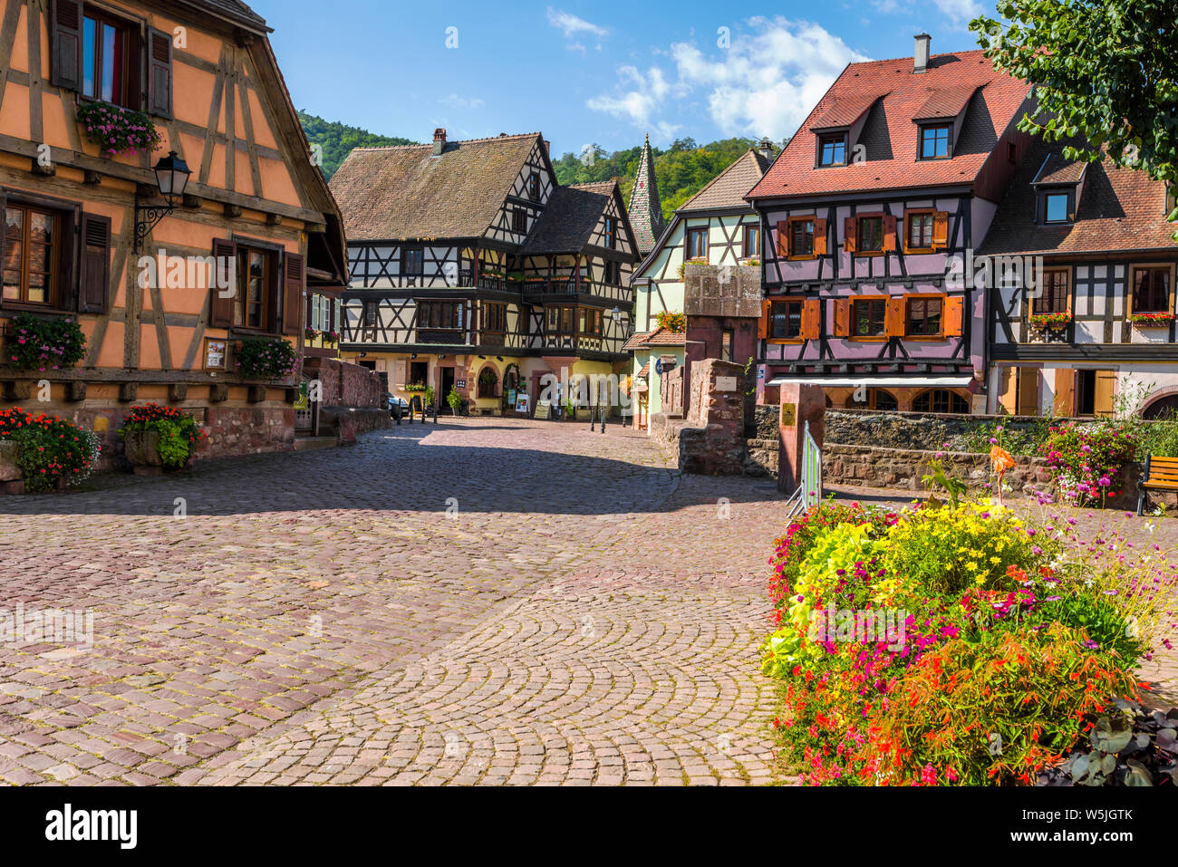 Pintoresco rincón del centro de Kaysersberg, Alsacia, Francia, casco antiguo con coloridas casas con entramados de madera y puente de piedra Foto de stock