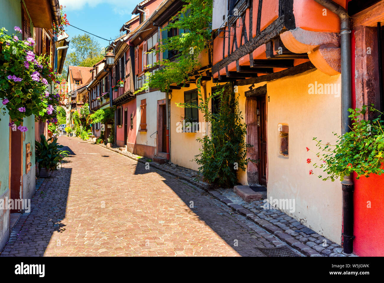 Colorido pintoresco Lane en la vieja ciudad de Kaysersberg, Ruta del Vino de Alsacia, Francia, casas con entramados de madera con decoración floral Foto de stock