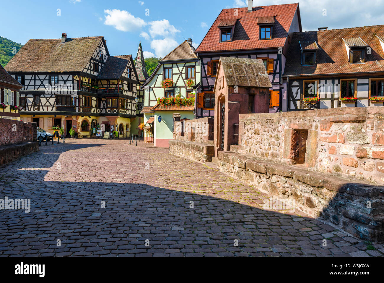 Pintoresca ciudad vieja en el centro de Kaysersberg, Alsacia, Francia, antigua ciudad con coloridas casas con entramados de madera y puente de piedra Foto de stock