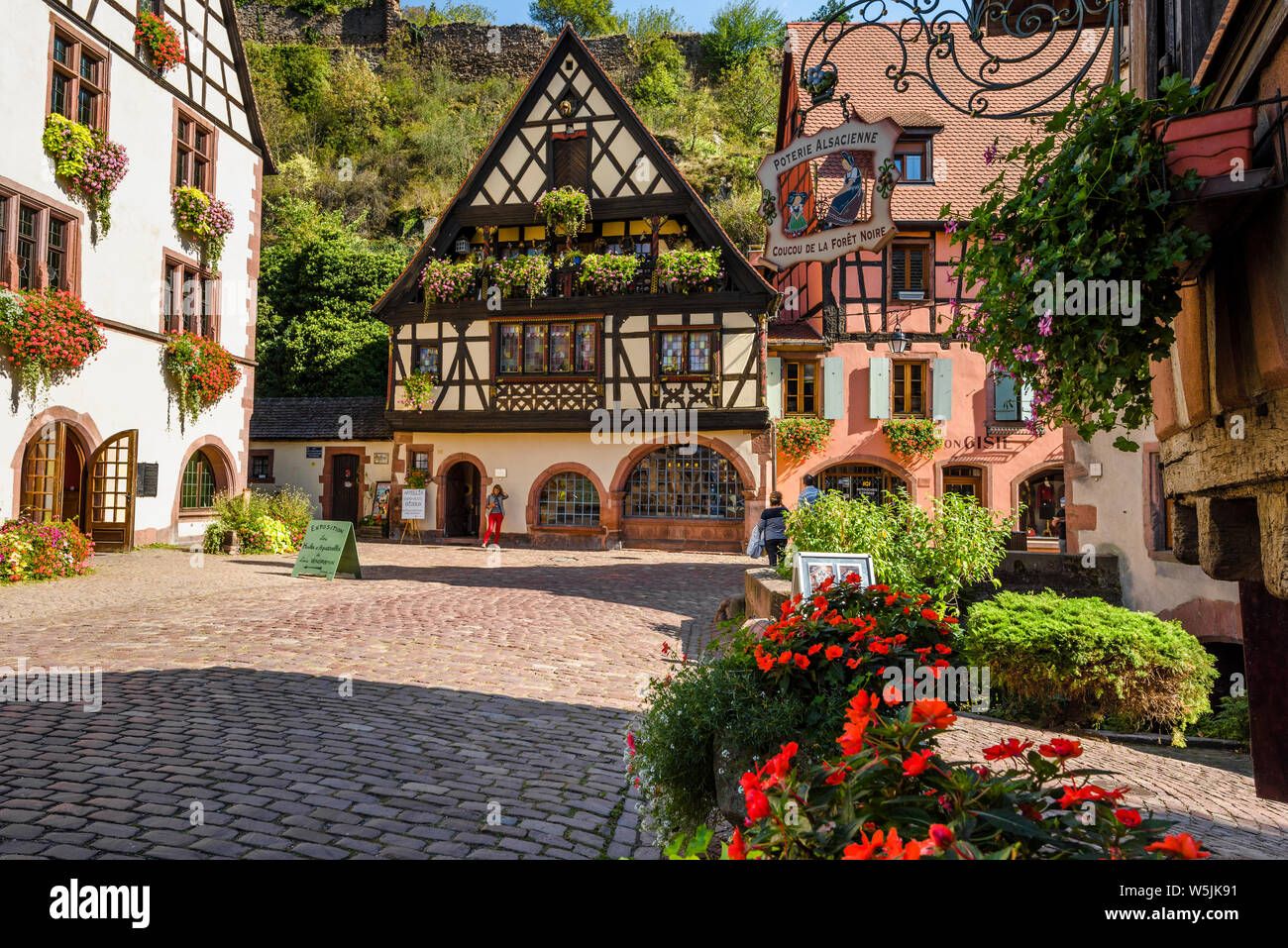 La pintoresca plaza con casas de entramado de madera en la antigua ciudad de Kaysersberg, La Ruta del Vino de Alsacia, Francia, destino turístico con carácter medieval Foto de stock