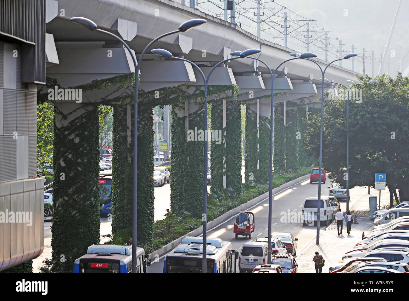 Una fila de pilares de una línea de metro elevado está cubierto con reductor  de plantas en barrio Shapingba, Chongqing, China, 9 de abril de 2019.  Plantas reductor gre Fotografía de stock - Alamy