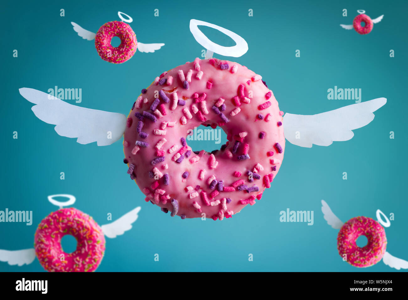 Cute angel donuts con alas de papel blanco y Nimbus sobre un fondo azul,lindo tarjeta navideña Foto de stock