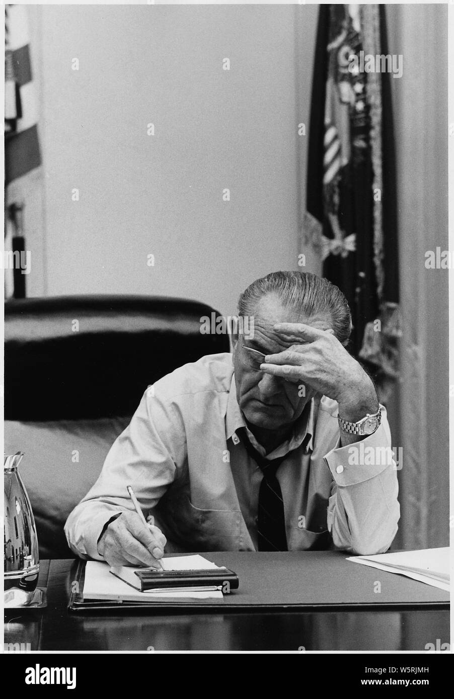 Humor: el Presidente Lyndon B. Johnson haciendo notas en una reunión de Sala del Gabinete; alcance y contenido: Ubicación: Sala de Gabinete de la Casa Blanca. Representado: el Presidente Lyndon B. Johnson. Foto de stock