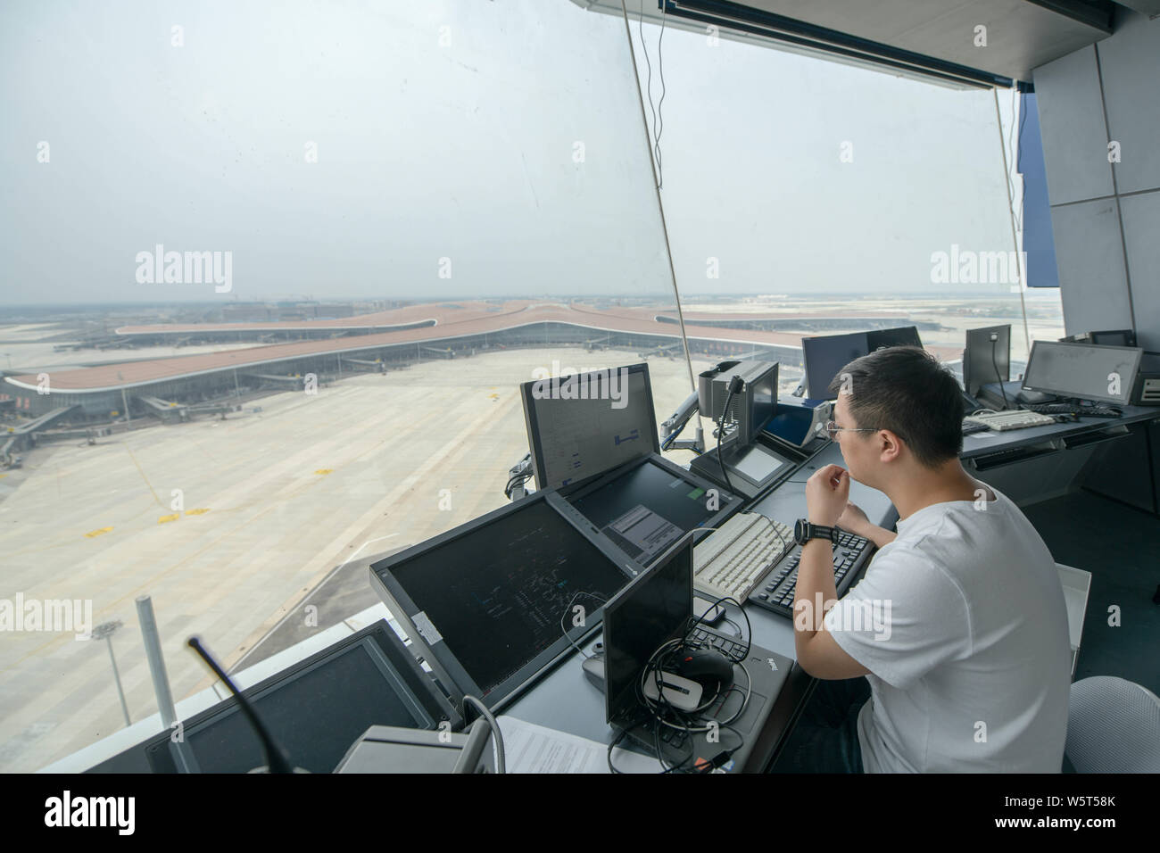 Un trabajador chino es visto en la torre de control del tráfico aéreo, conocido como el "ojo de Fénix", en el Aeropuerto Internacional de Pekín Capital en Beijing, Chi Foto de stock