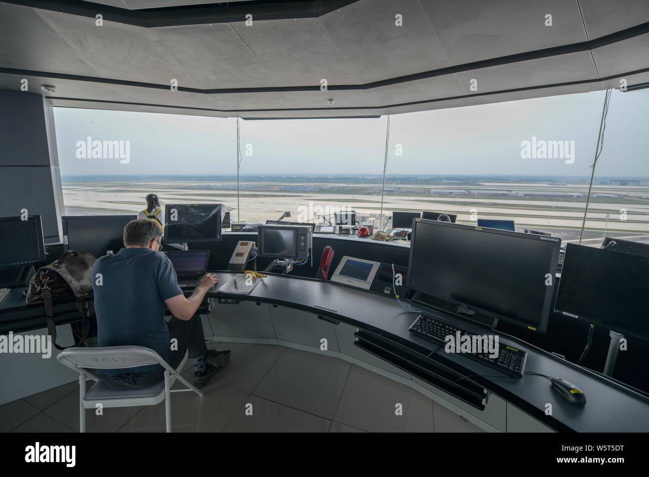 Un trabajador chino es visto en la torre de control del tráfico aéreo, conocido como el "ojo de Fénix", en el Aeropuerto Internacional de Pekín Capital en Beijing, Chi Foto de stock