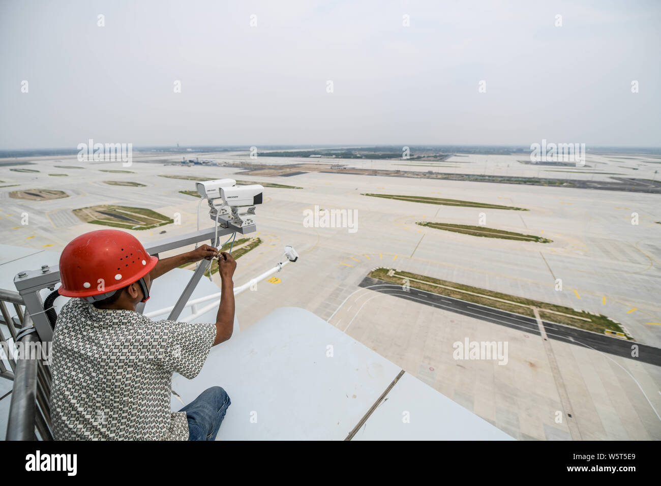 Un trabajador chino es visto en la torre de control del tráfico aéreo, conocido como el "ojo de Fénix", en el Aeropuerto Internacional de Pekín Capital en Beijing, Chi Foto de stock
