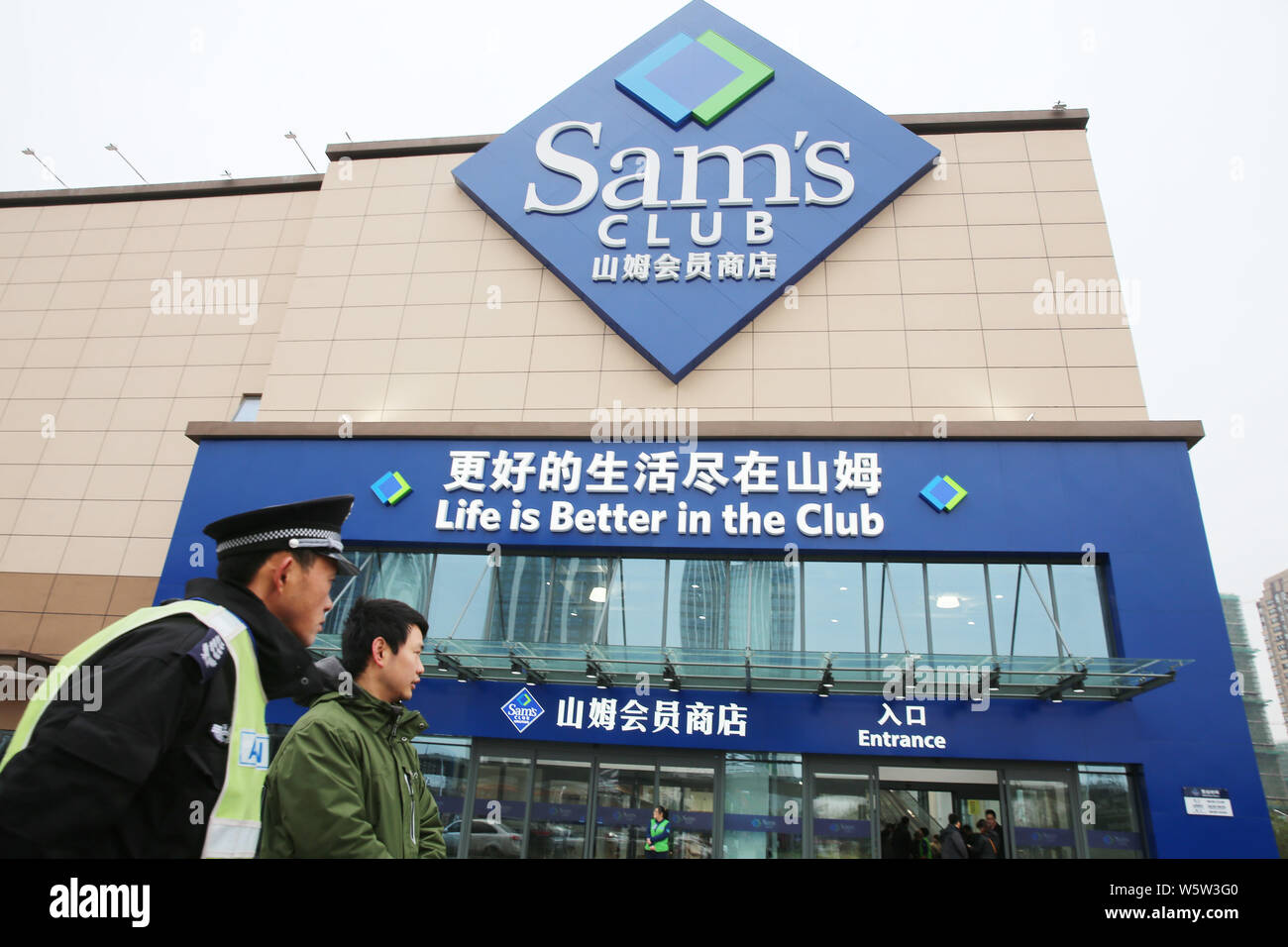 La gente camina más allá del almacén almacén de Sam's Club, su 23ª salida  en China, en la ciudad de Nantong, provincia de Jiangsu de China oriental,  el 25 de diciembre de
