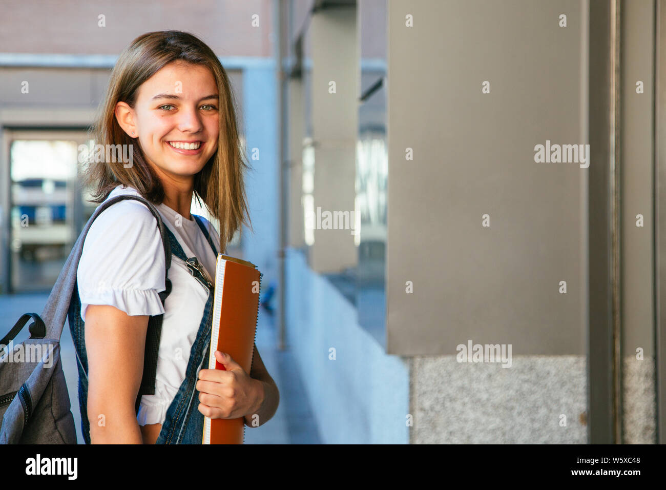 Joven hermosa estudiante asiática, con una mochila, camina en el parque con  un scooter eléctrico, en el verano en la calle Fotografía de stock - Alamy