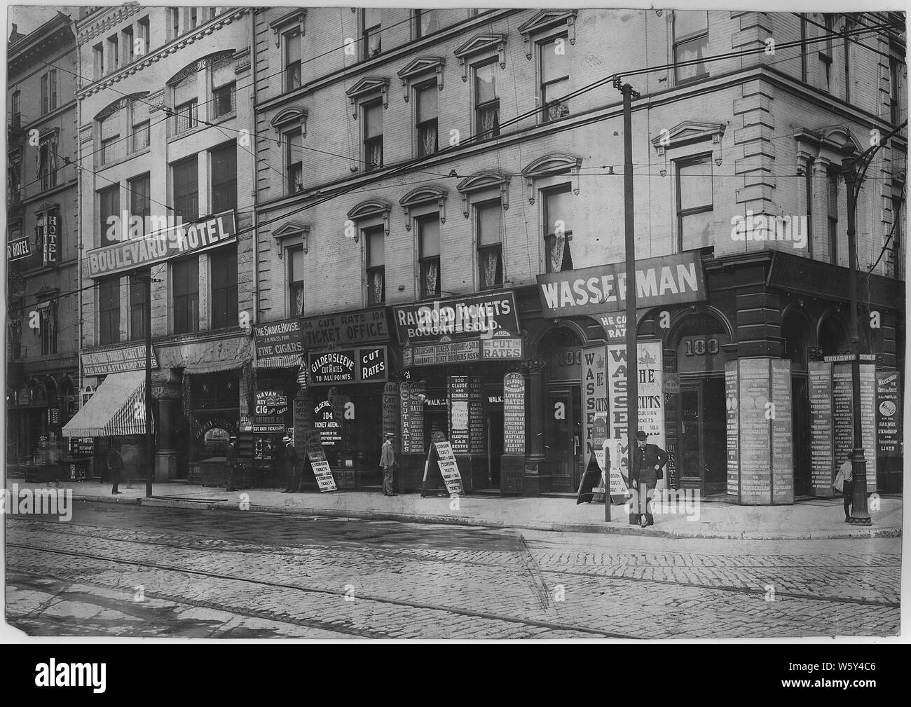Escenas Callejeras mostrando billete de ferrocarril oficinas broker en Market Street en St.; alcance y contenido: Otras empresas indicadas incluyen el Grand Union Hotel, Portland Hotel, Hotel Bulevar, y un supermercado. Algunas fotografías son peatones y comerciantes. Nº 15 es un pedido de intercambio de broker S. Steiner. Foto de stock