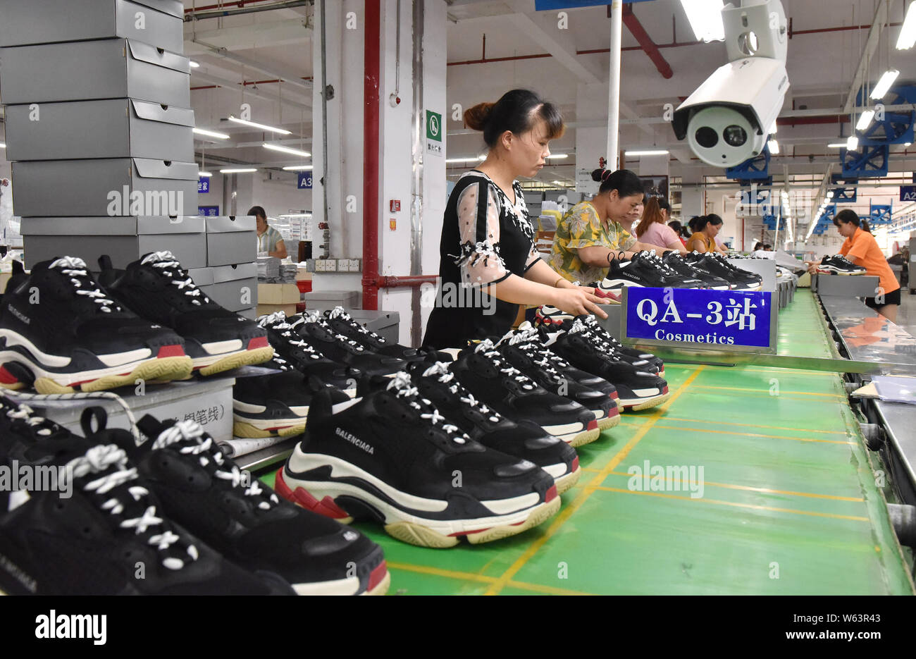 Los trabajadores chinos fabrican zapatillas para ser exportados en una  fábrica de una compañía de zapatos en la ciudad de Loudi, provincia de  Hunan, en China central, 3 de septiembre de 2018