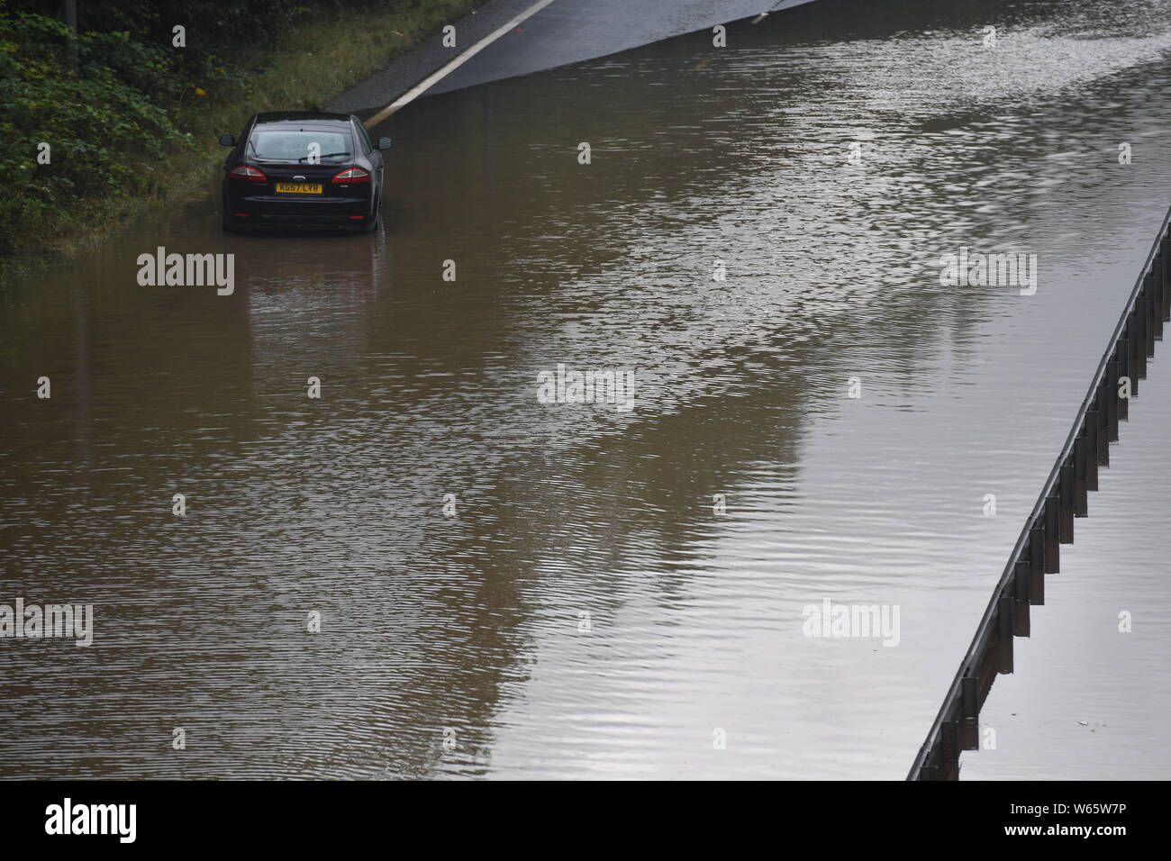 Un vehículo varado en las aguas de la inundación que ha cerrado el A555 en Stockport, Manchester. Foto de stock