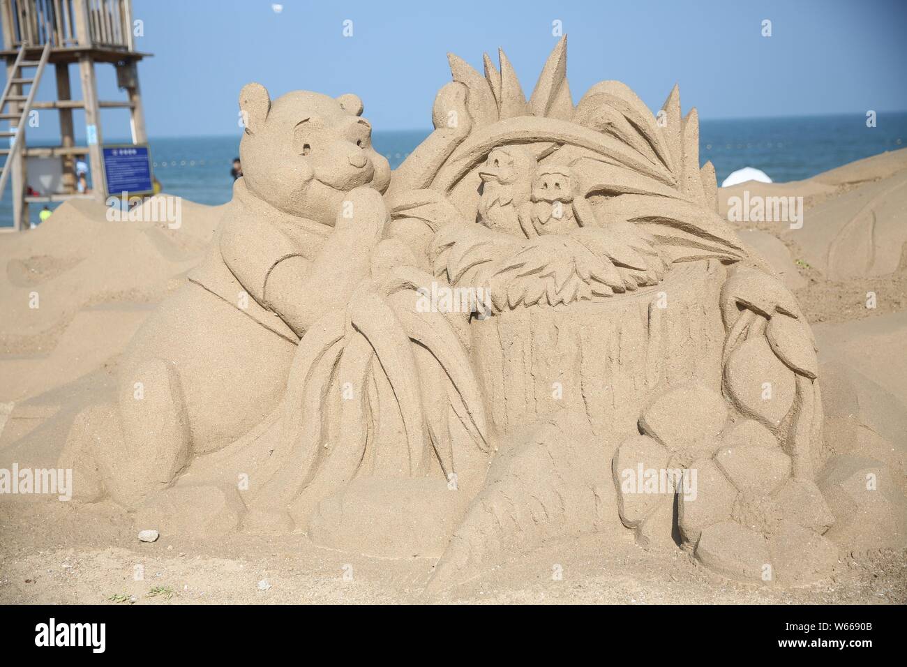 Una escultura de arena de los personajes de las producciones animadas de Disney 'Winnie-the-pooh'está en exhibición en una playa en Rizhao, East china Shandong Provinc Foto de stock