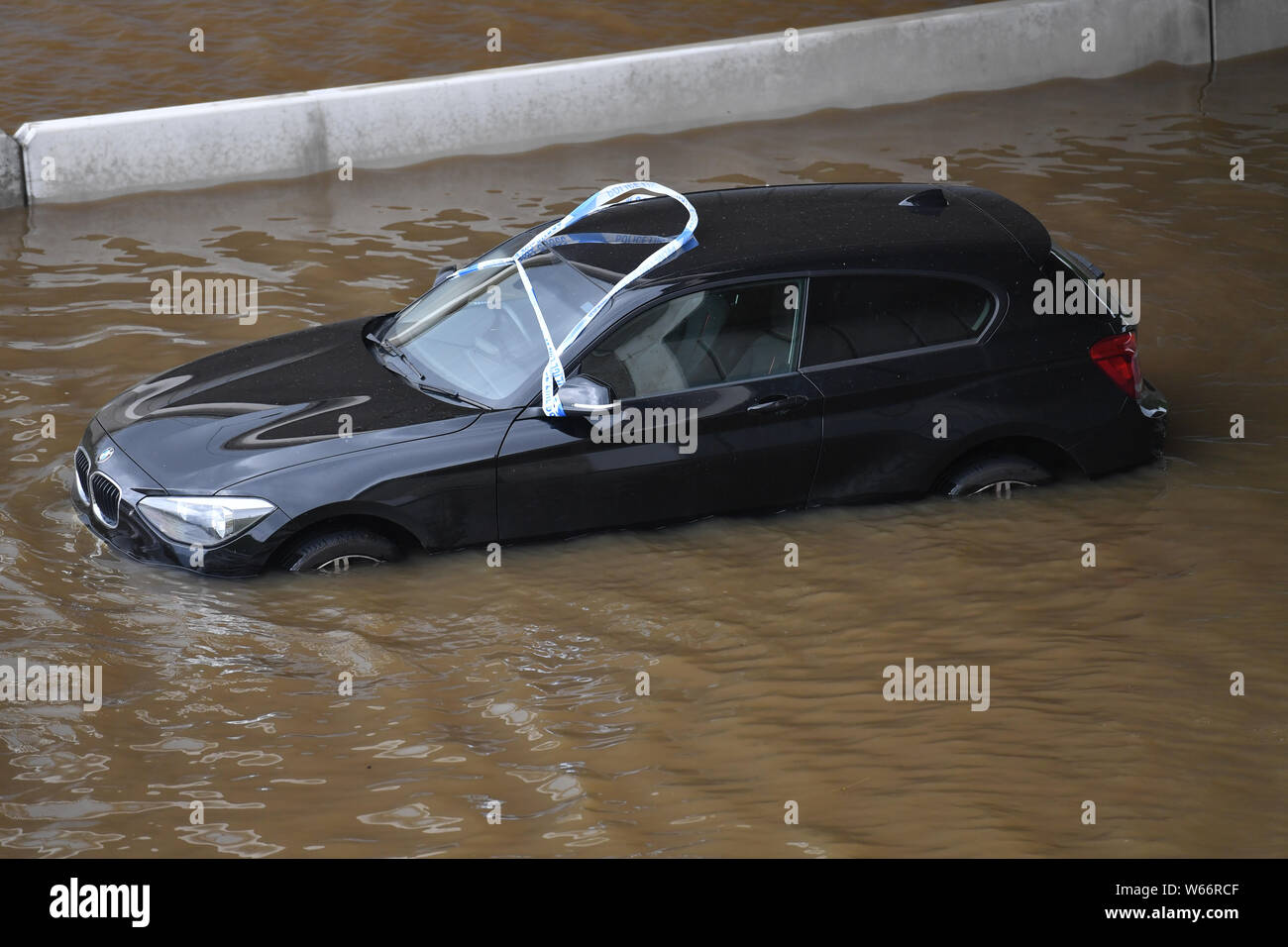 Un coche encallado en las aguas de la inundación en la A555 cerca de Handforth, Greater Manchester, tras la intensa lluvia del martes. Foto de stock