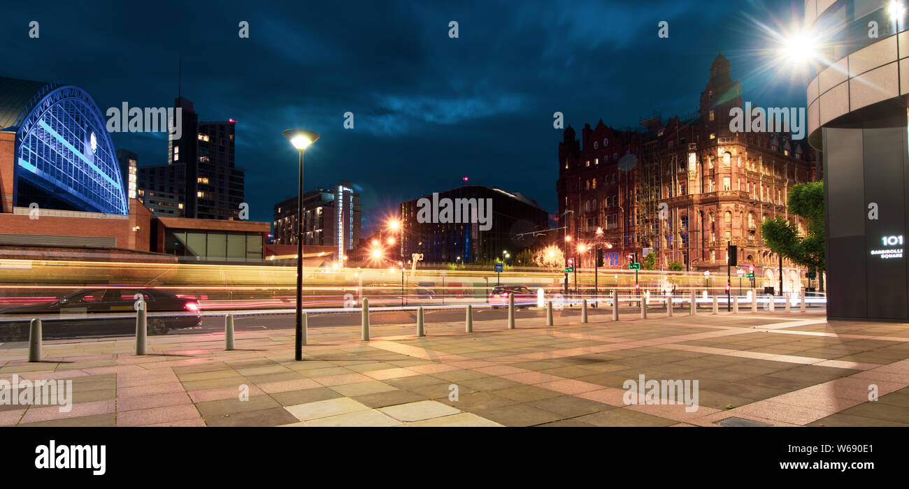 La larga exposición a la noche del tranvía pasando la calle Mosley inferior con Manchester Central, Midland Hotel y 101 edificio Barbirolli en la espalda Foto de stock