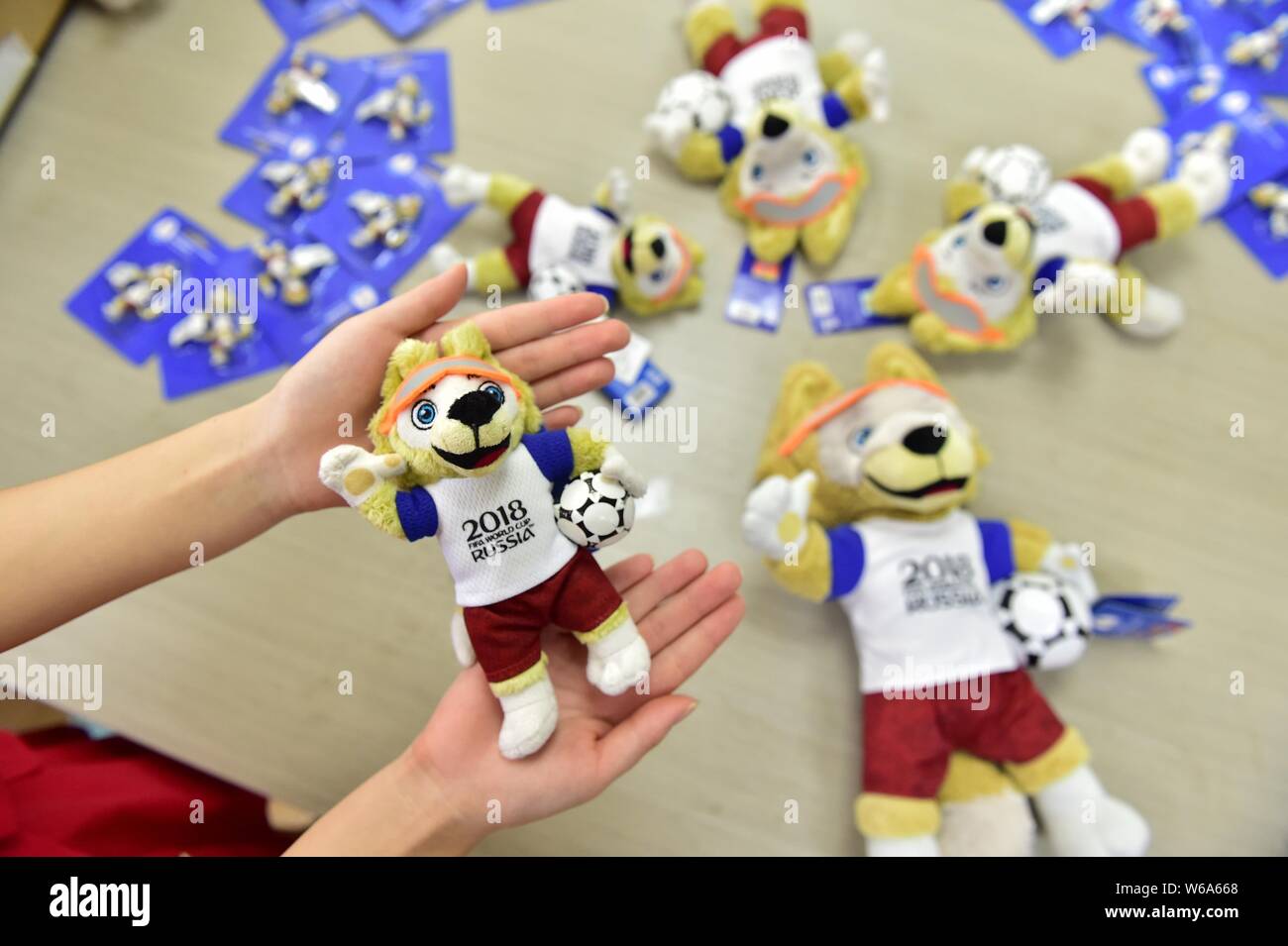 Un trabajador chino muestra un animal de peluche con licencia de Zabivaka  el lobo, la mascota de la Copa Mundial de la FIFA 2018, en el almacén de un  transfronteriza chino Fotografía