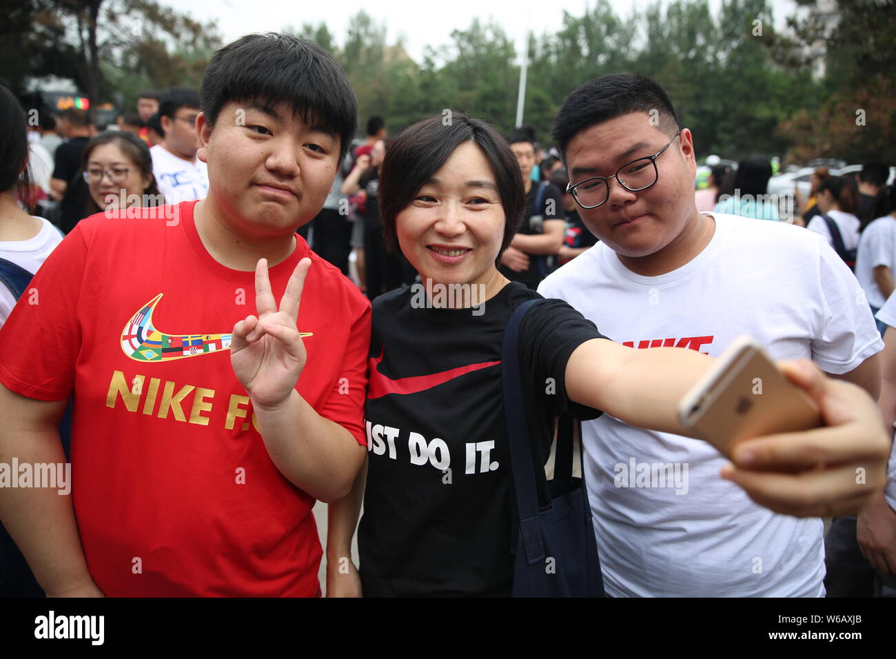 Los estudiantes chinos vistiendo camisetas Nike en espera de sus respuestas bien con su profesor antes de presentarse al examen de ingreso universitario nacional Fotografía de stock - Alamy