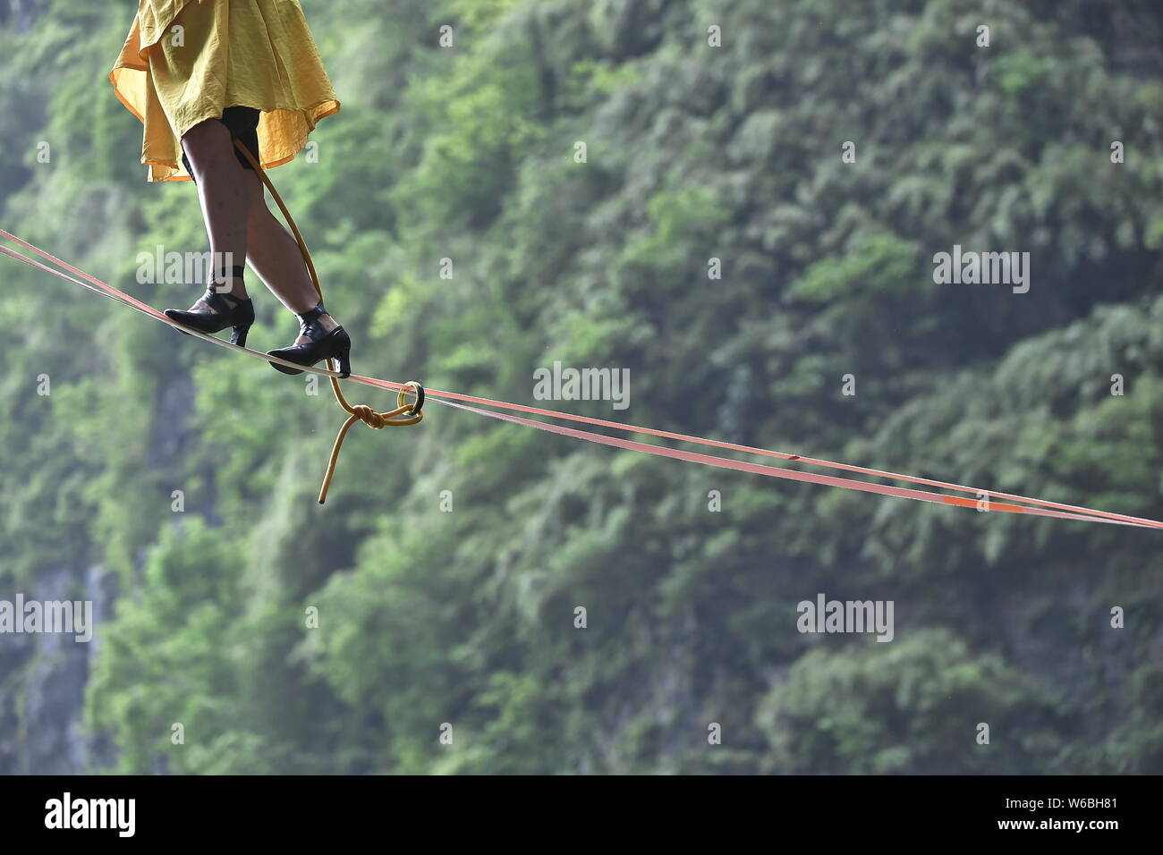 Mia Noblet de Canadá participa en un concurso de slackline en tacones altos en un debut mundial desafío a través de los acantilados de la montaña Tianmen (o Tianmensha Foto de stock