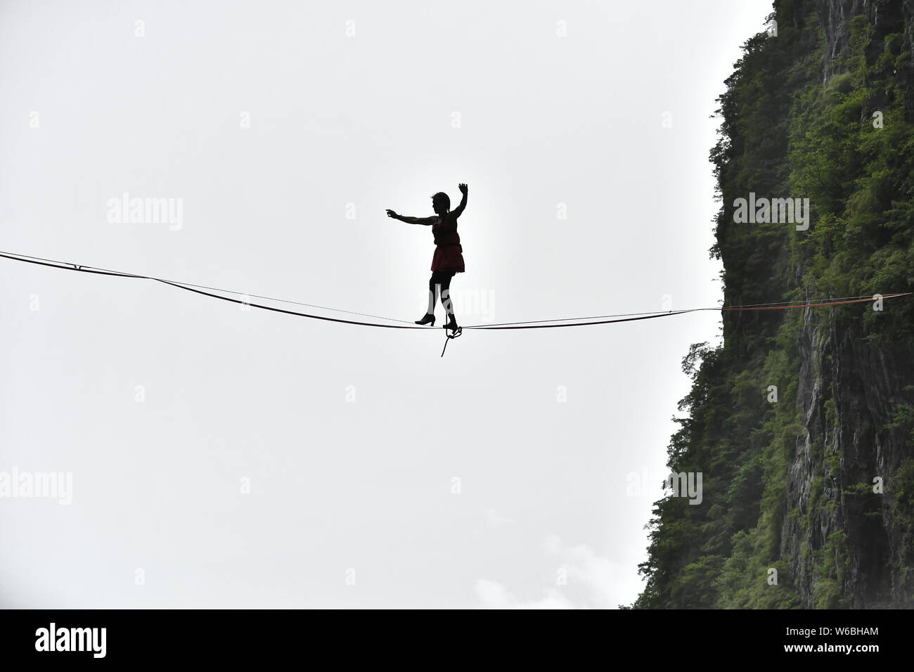 Mimi Guesdon de Francia participa en un concurso de slackline en tacones altos en un debut mundial desafío a través de los acantilados de la montaña Tianmen (o Tianmens Foto de stock