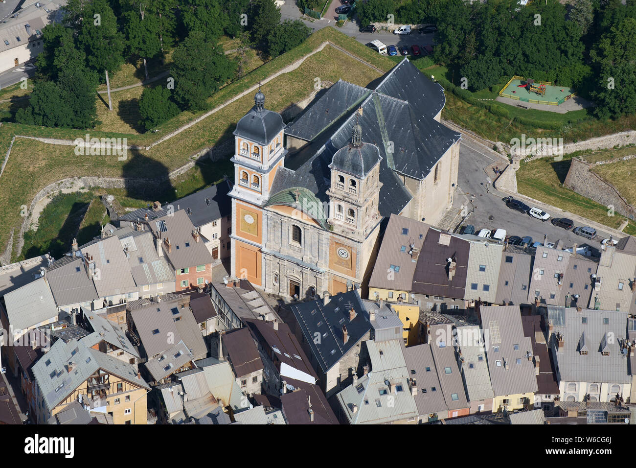 VISTA AÉREA. Collégiale Notre-Dame y Saint-Nicolas con vistas a los tejados del casco antiguo. Briançon, Altos Alpes, Francia. Foto de stock
