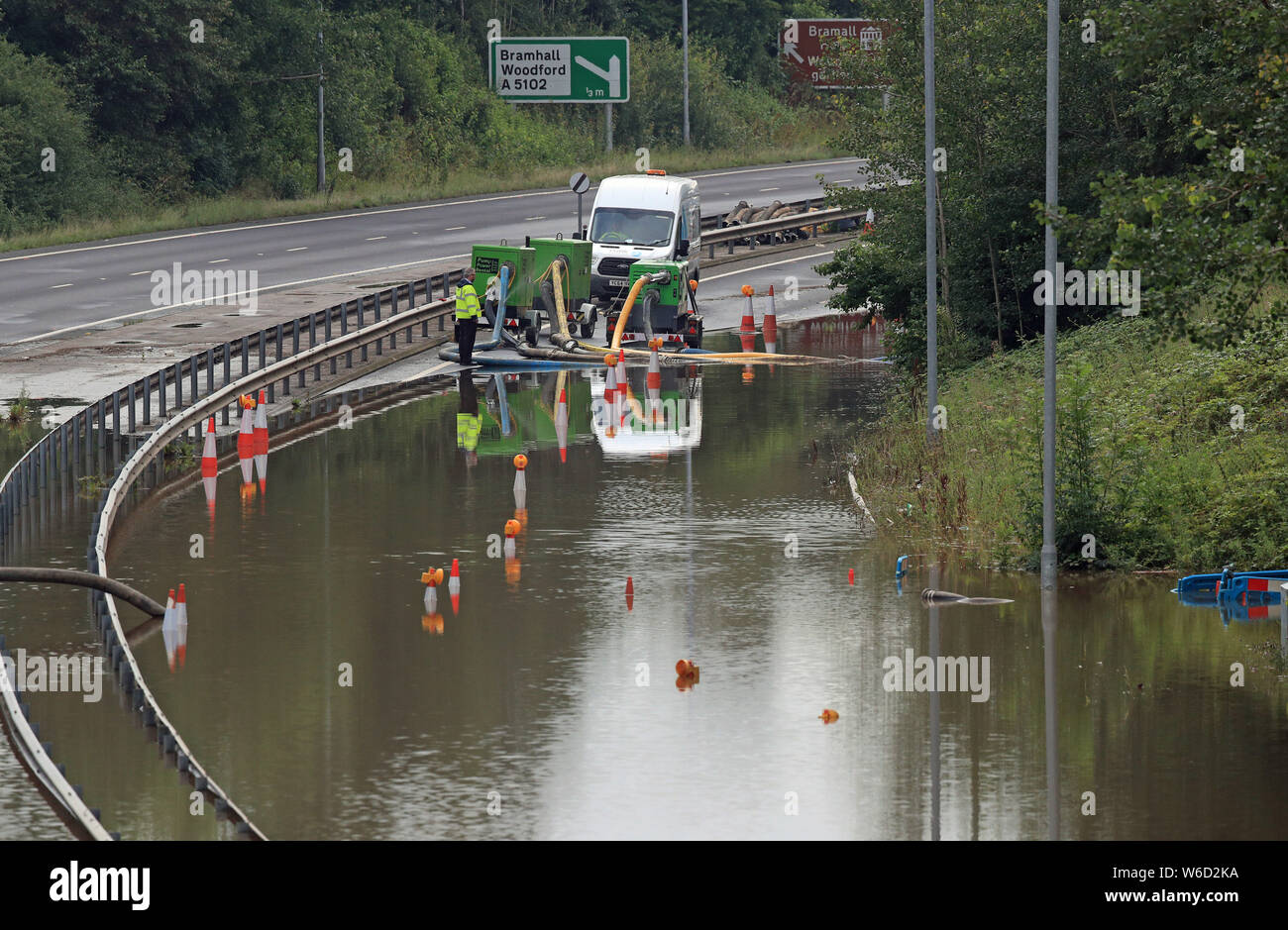 El agua se bombea rfom el A555 cerca de Kitt's Moss en Bramhall, Cheshire, donde un importante incidente fue declarado tarde el miércoles después de fuertes lluvias causaron graves inundaciones. Foto de stock
