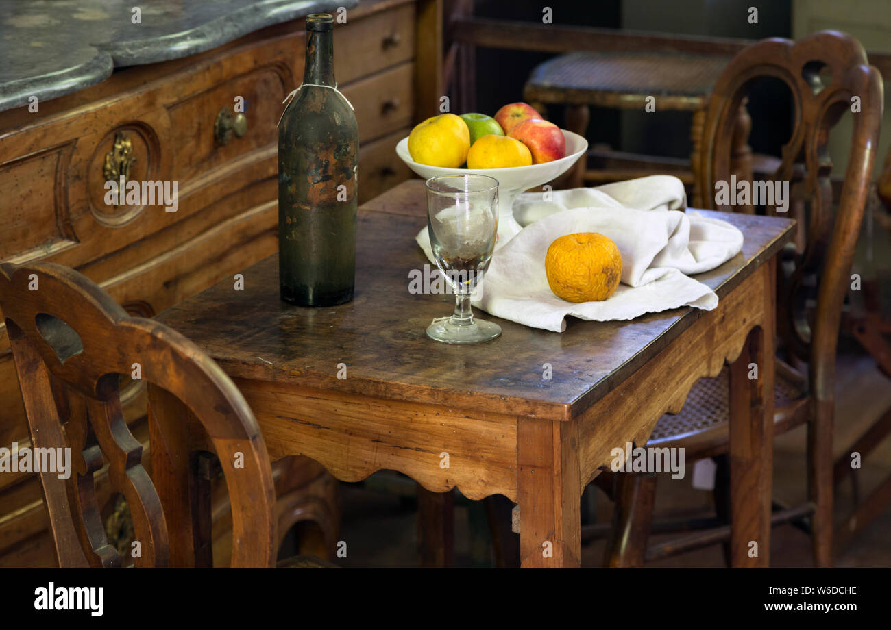 Fruta, vino y botella de vidrio arreglo con muebles de época en el estudio del pintor postimpresionista francés Paul Cezanne en Aix-en-Provence, Prov Foto de stock