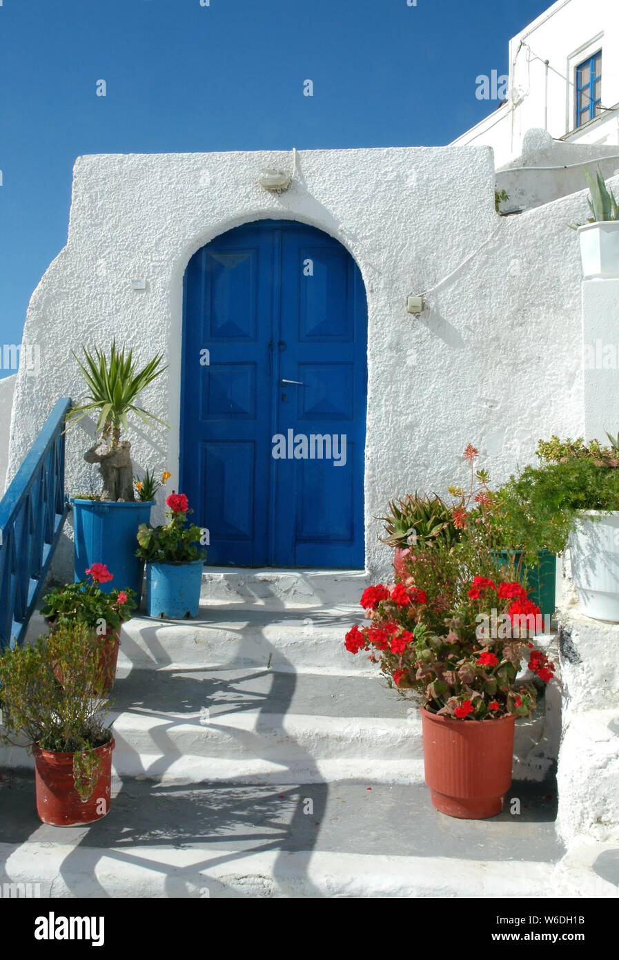 Una casa tradicional en Fira, Santorini, Grecia. Casas en Santorini a  menudo son azul y blanco. Los pasos hasta una puerta azul y paredes blancas  en Fira Santorini Fotografía de stock -