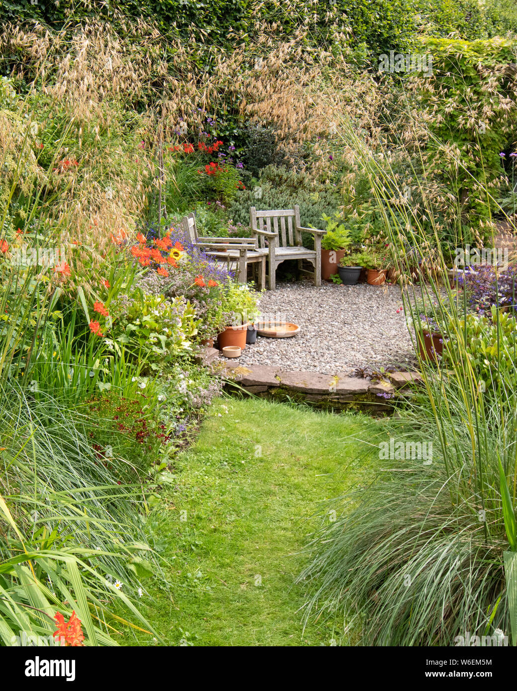 Área de asientos en el jardín frondoso jardín informal - UK Foto de stock