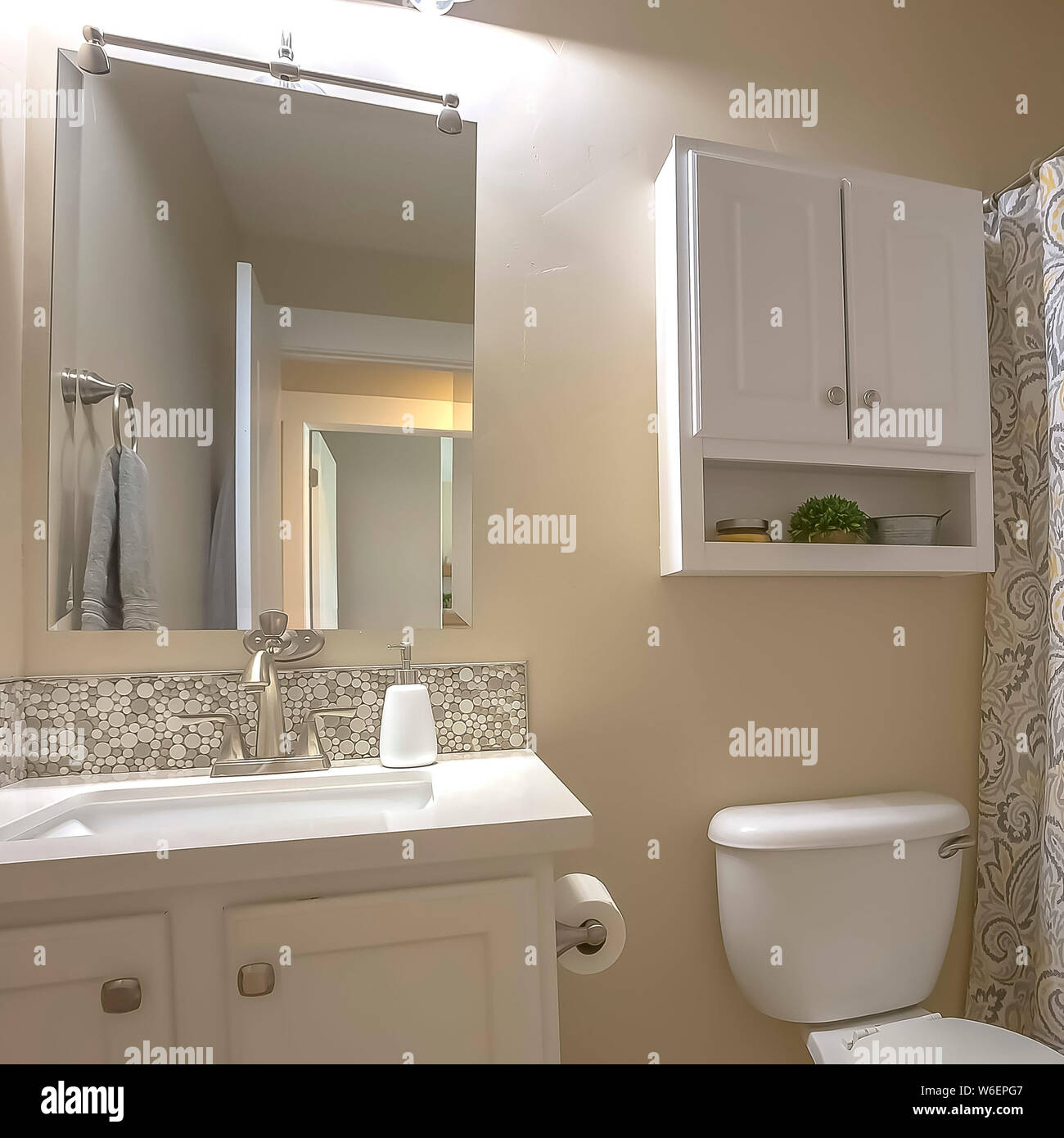 Wc cuadrado espejo de tocador y armario Baño interior con pared beige y  piso de mosaico Fotografía de stock - Alamy