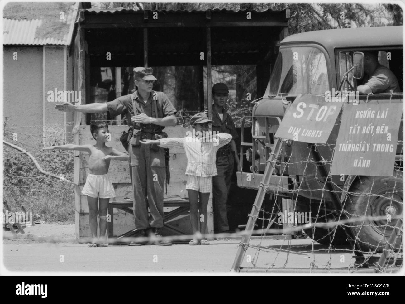 Da Nang, Vietnam...durante horas cada día, el Marine MP en Da Nang del Checkpoint Charlie asistencia tiene como vehículos a través de cheques. Los jóvenes son el Tai, izquierda y Vo, los hijos del sargento de la fuerza aérea vietnamita que vive en la base. El Marine se lance el Cabo James T. Carter. Foto de stock