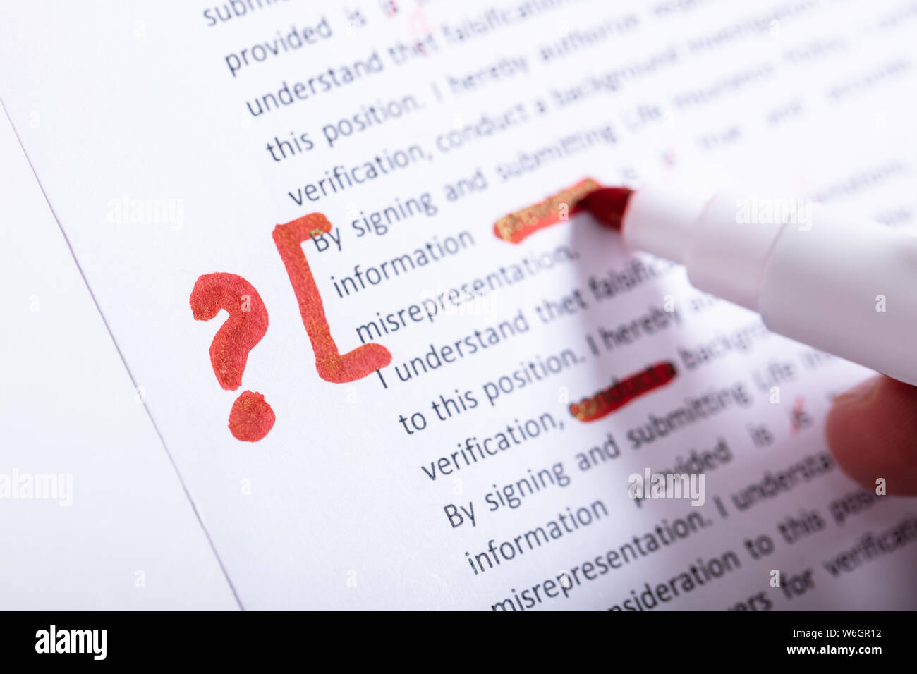 Mano humana mantiene un marcador rojo durante la verificación