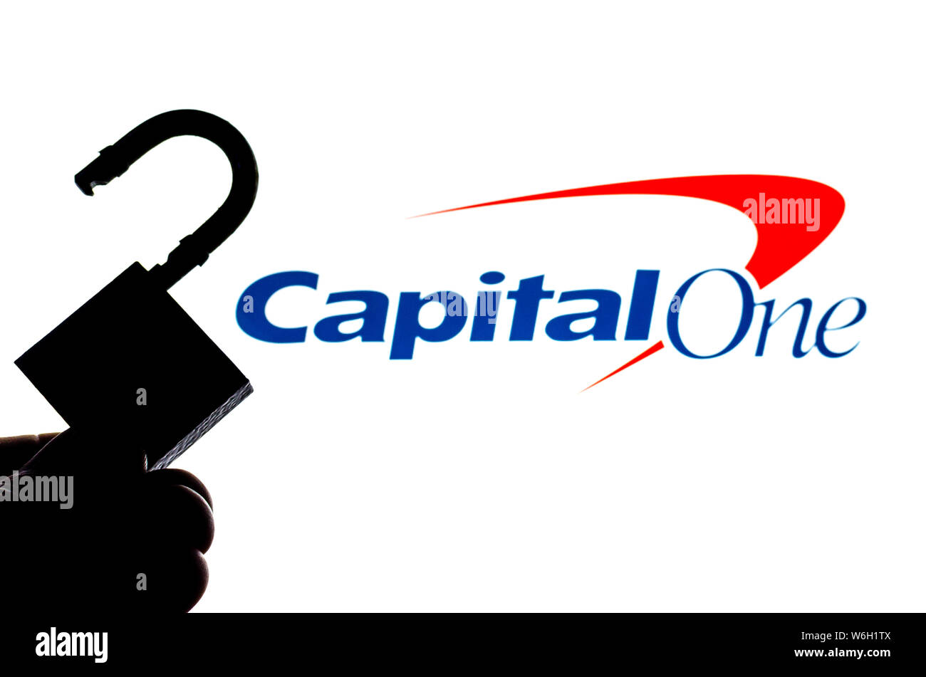 Capital One Bank logotipo en la pantalla de fondo y una silueta del bloqueo abierto en la parte delantera. Foto conceptual para las noticias acerca de la fuga de datos. Foto de stock