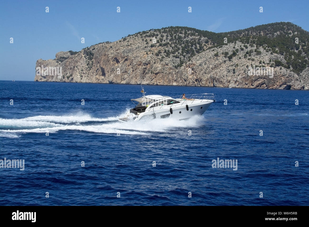 MALLORCA, España - Junio 23, 2019: barco de motor con la mujer aceleración haciendo olas espumosas en un soleado día de junio 23, 2019 en Mallorca, España. Foto de stock