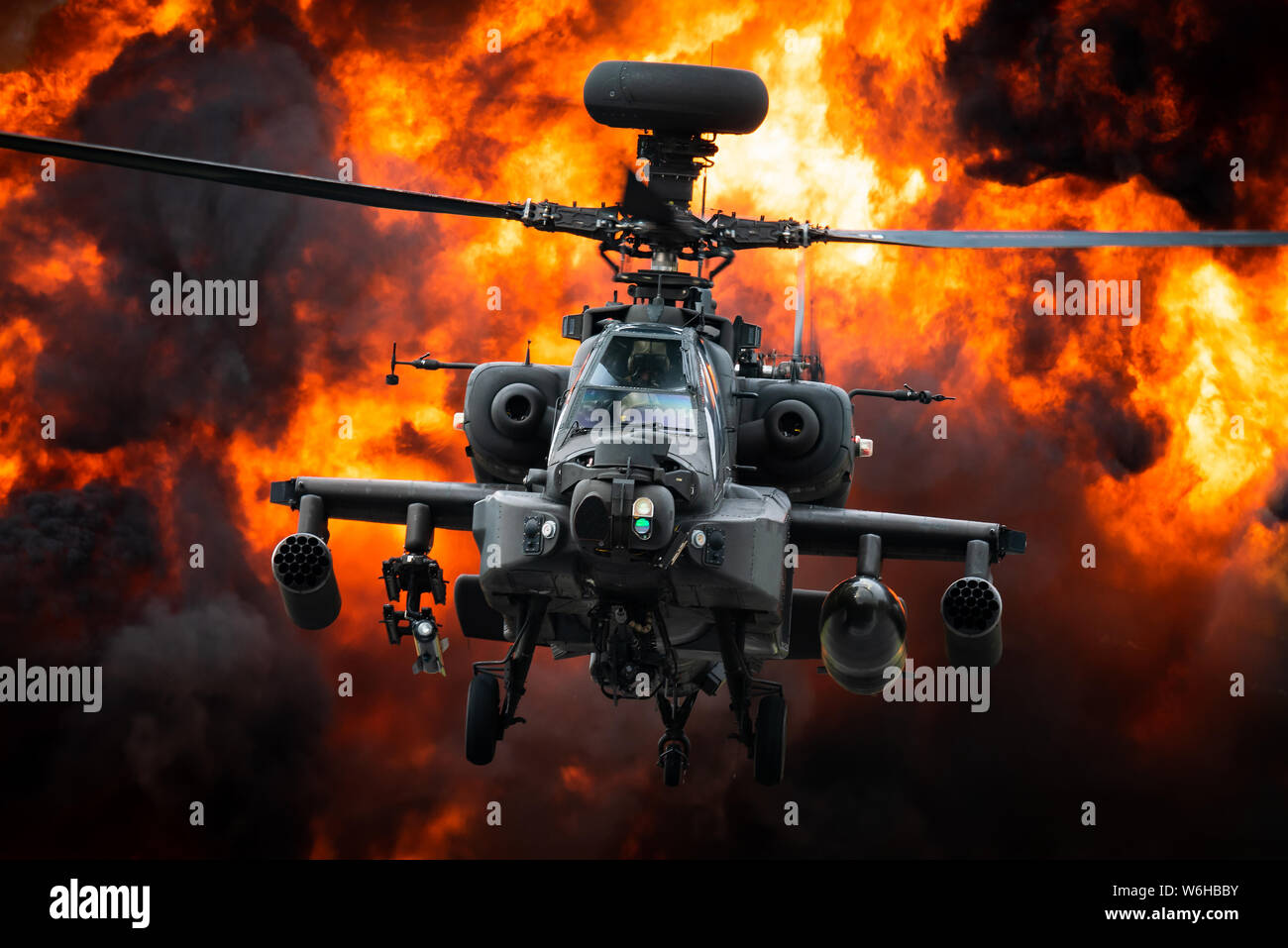 Un AgustaWestland helicópteros de ataque Apache del Ejército del Aire en frente de una gran explosión. Foto de stock