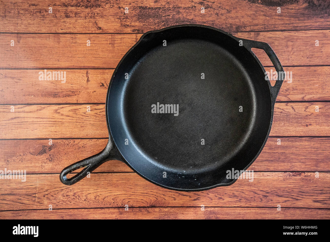 Heavy Duty tradicionales Cast Iron Skillet sobre superficie de madera - vista superior aislado con espacio de copia. Negro utensilio de cocina - utensilios de cocina y campfire kitchenw Foto de stock