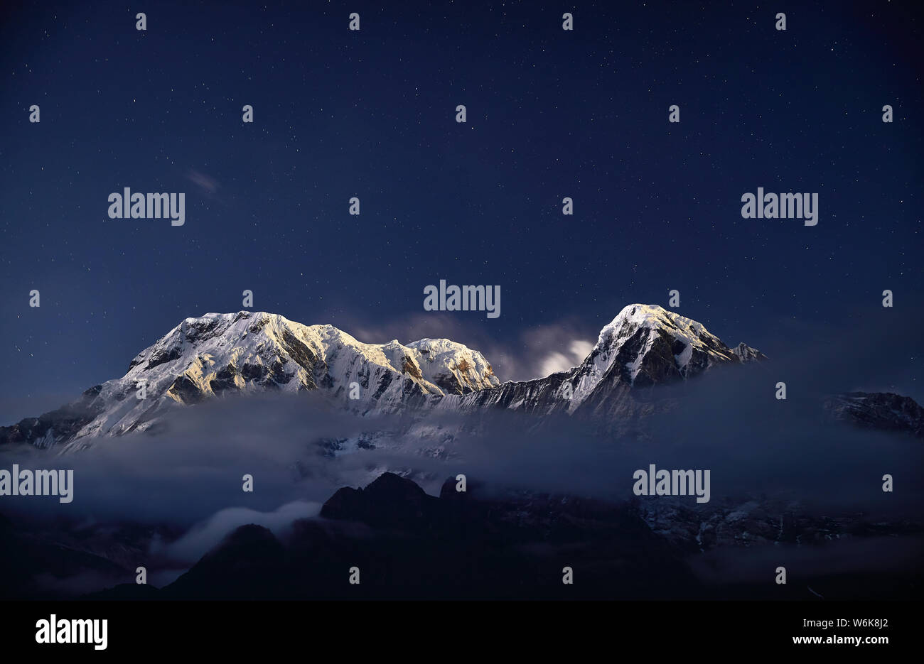 Annapurna y nevadas montañas Hinchuli durante la noche el cielo estrellado en Nepal Foto de stock