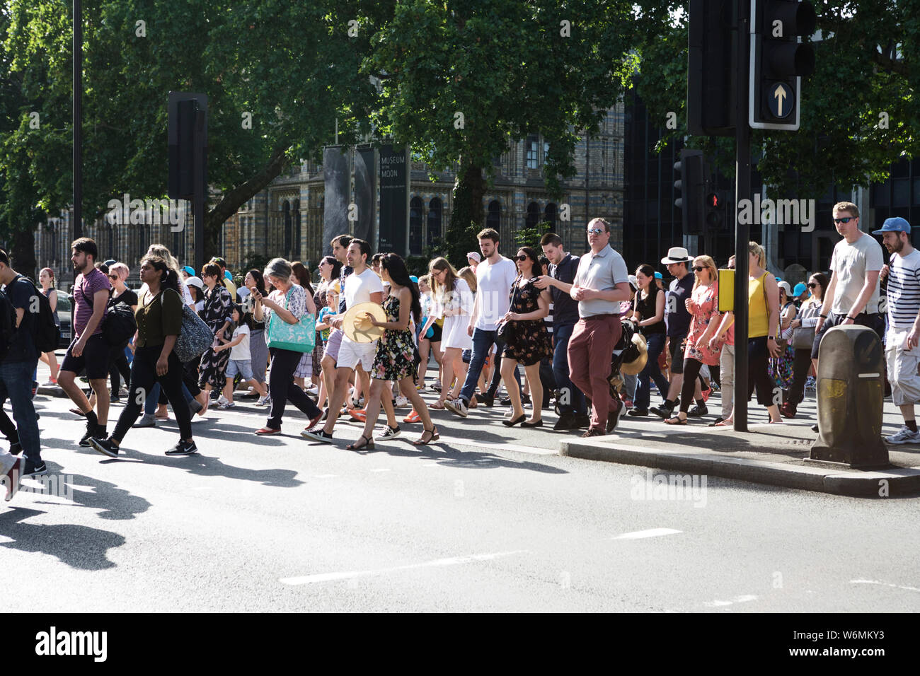 Gente cruzando la carretera, con el Museo de Historia Natural en el fondo, South Kensington, Londres, SW7. La raza humana. Pensiones. Seguro de vida. Contagio. Foto de stock