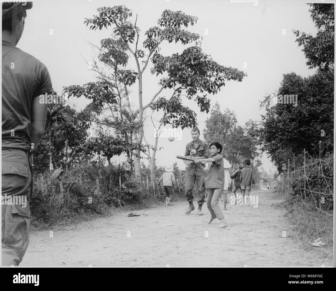 Vietnam...Los miembros del 3er Batallón del 187 de Infantería, la 101ª División Aerotransportada (Airmobile), únete a los hijos de ap Uu Thoung hamlet en un juego de béisbol. Los troopers son miembros de un batallón acción equipo involucrado en las operaciones de pacificación en Phong Dieu, distrito norte de Hue. Foto de stock