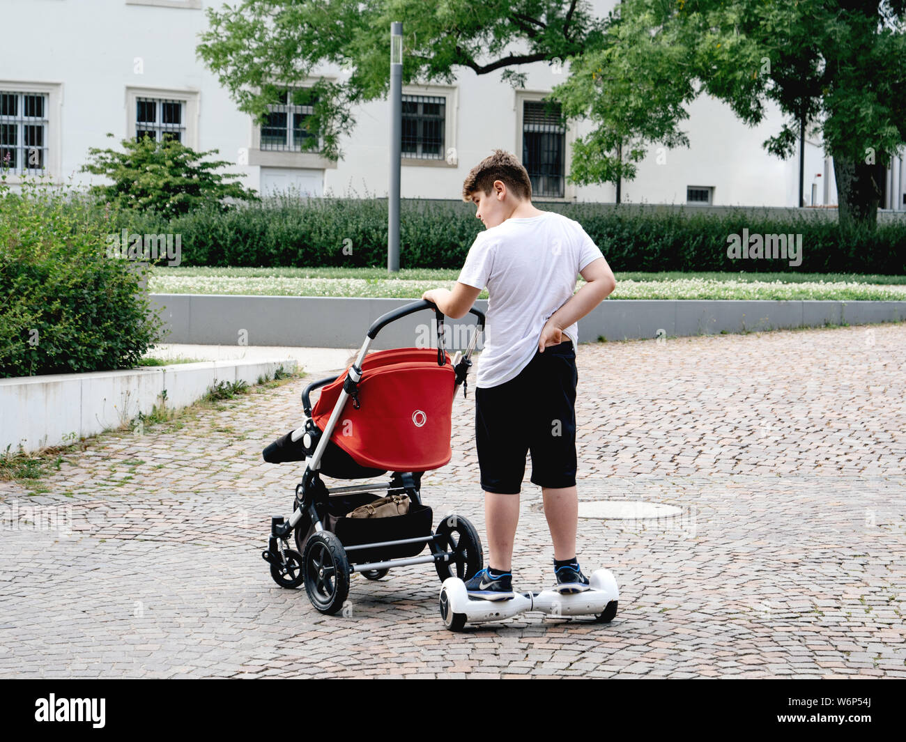 Baden-Baden, Alemania - 7 jul, 2019: perezoso joven empujando carrito  cochecito con el bebé mientras viajaba en un hoverboard eléctrico en las  calles adoquinadas de Baden-Baden Fotografía de stock - Alamy
