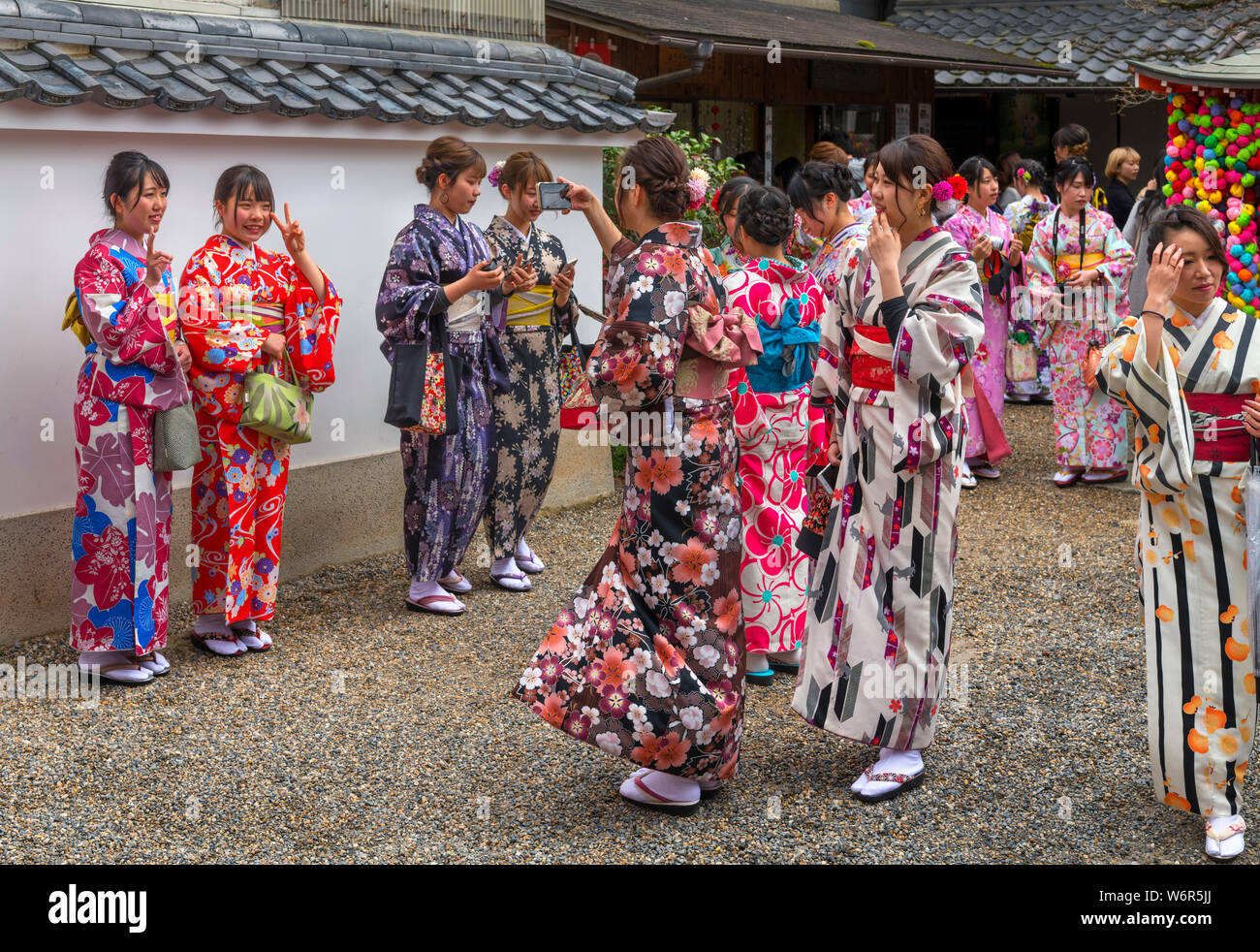Las mujeres jóvenes en los kimonos tradicionales tomando fotos en el patio de Yasaka Kongoji Kōshin-dō (Templo), el Distrito Higashiyama, Gion, Kioto, Japón Foto de stock