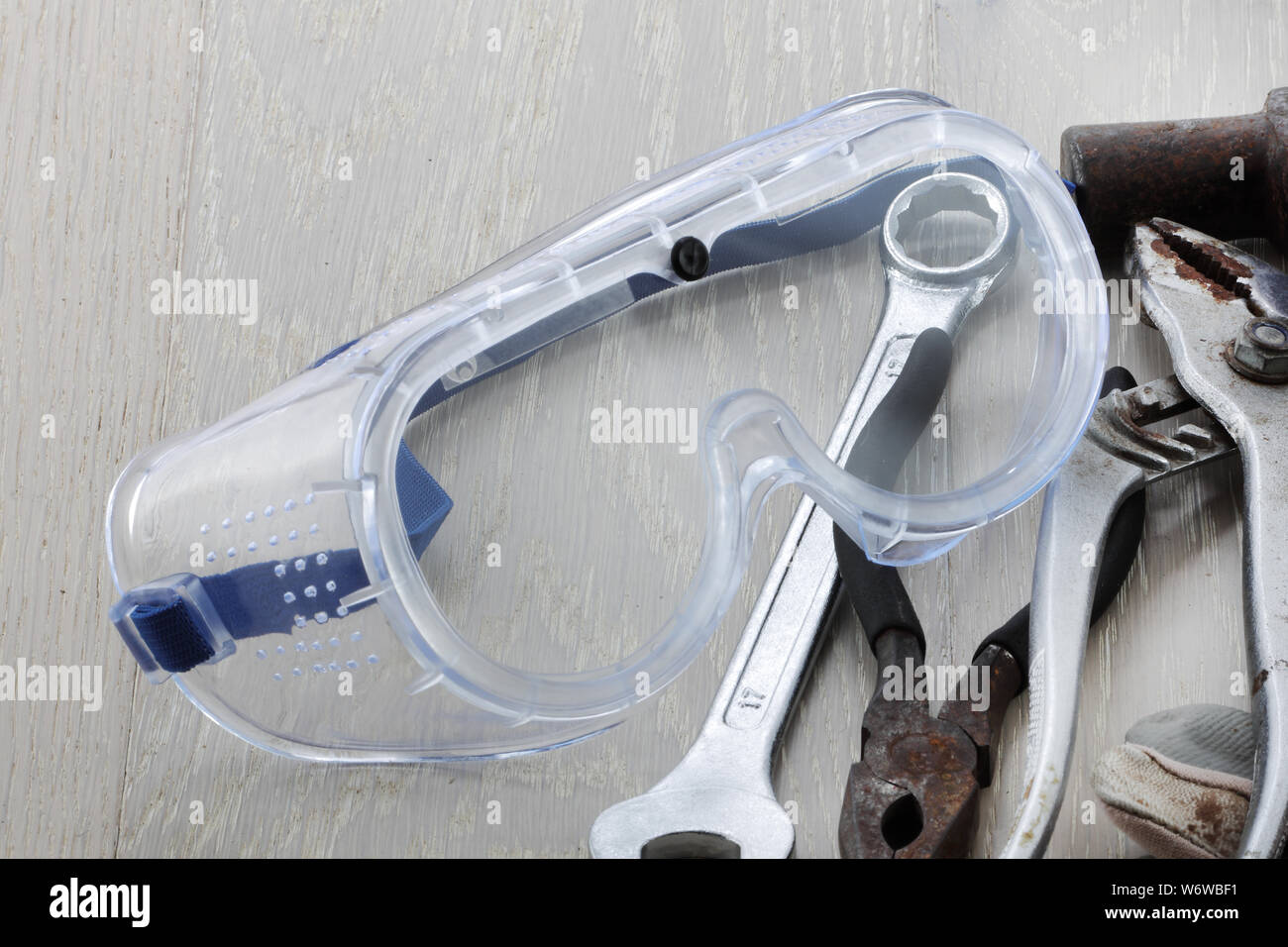 Un par de gafas de seguridad o gafas en un banco de trabajo con herramientas Foto de stock