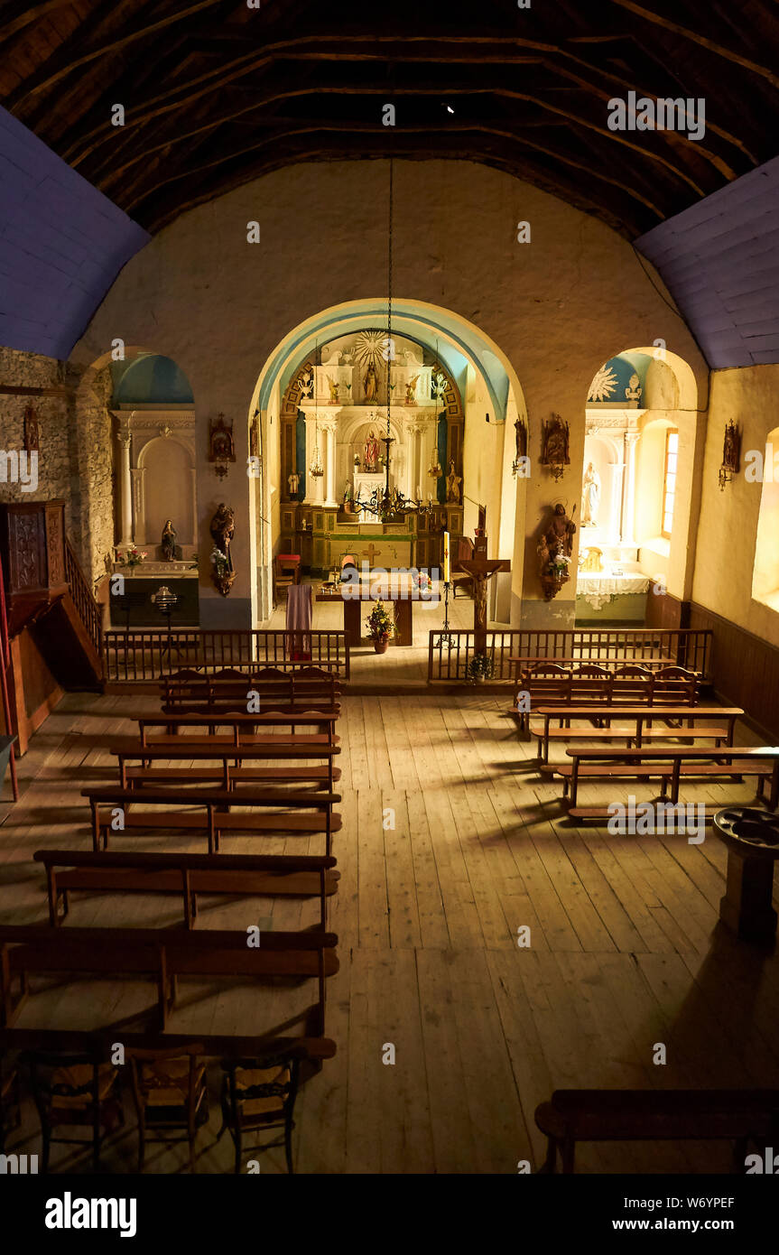 En el interior de Sant Sernilh iglesia del siglo XIX con altar, bancos y suelo de madera en Canejan (valle de Arán, Lleida, Pirineos, Cataluña, España) Foto de stock