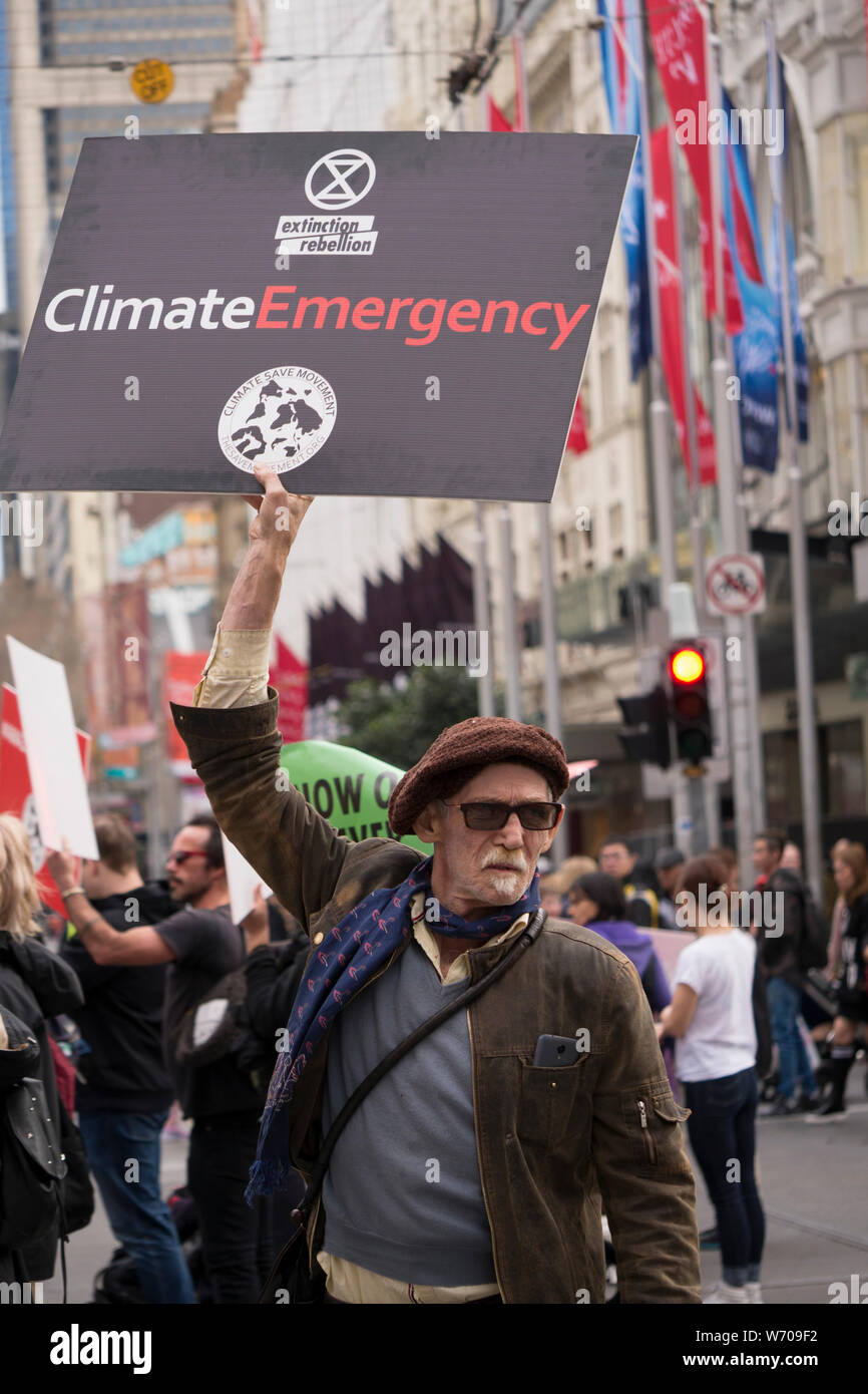 Manifestante de mediana edad vestidos de Beret con perilla gris negro sosteniendo una emergencia climática de signo en emergencia climática manifestación en el centro de Melbourne. Foto de stock