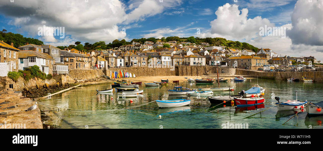 Reino Unido, Inglaterra, Cornwall, Mousehole, barcos amarrados en el puerto en marea baja por debajo de South Cliff, panorámicas Foto de stock