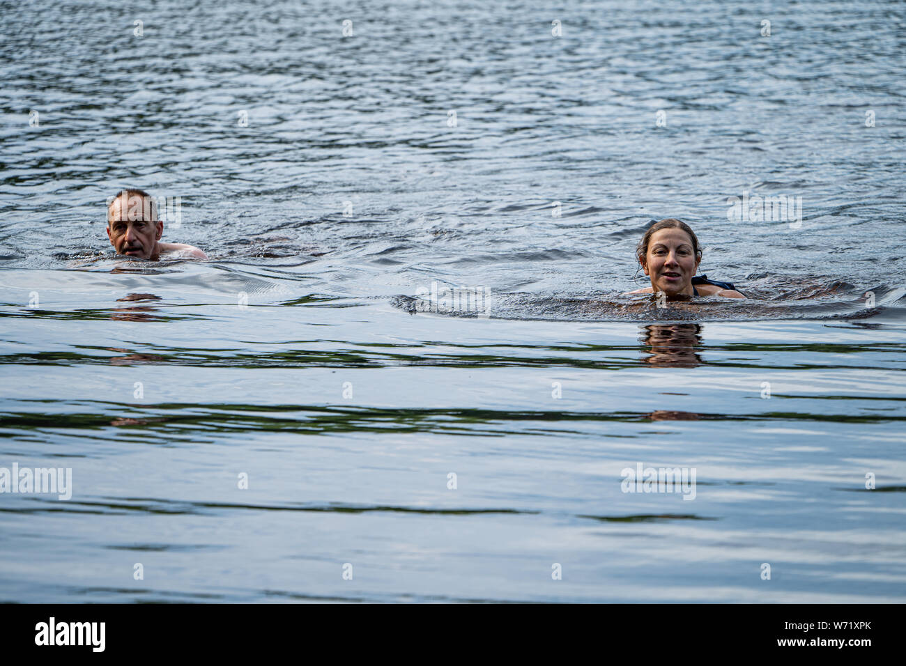 El hombre y la mujer salvaje nadando en el Río Negro (Svartälven), Suecia Foto de stock