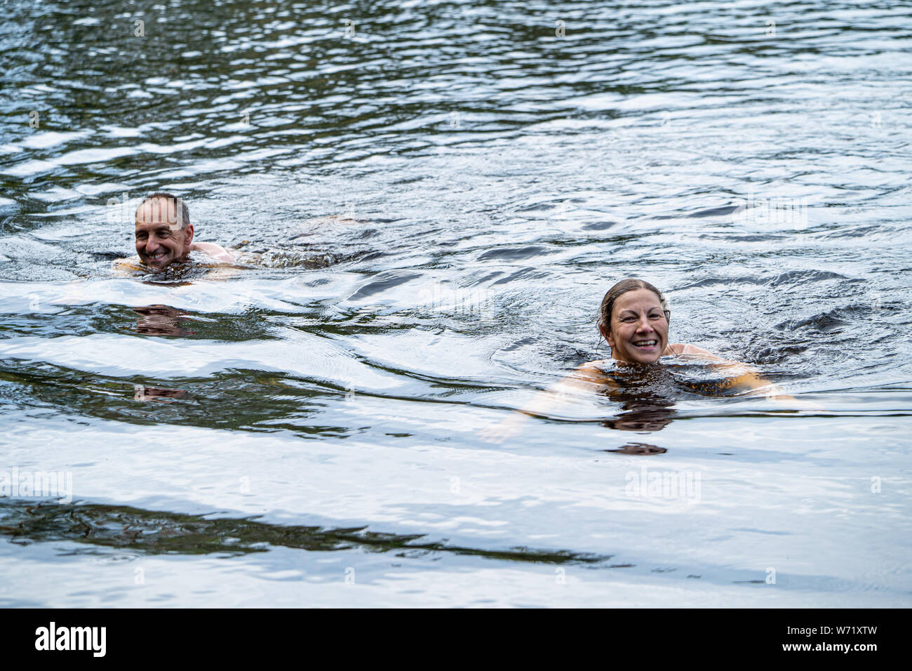 El hombre y la mujer salvaje nadando en el Río Negro (Svartälven), Suecia Foto de stock
