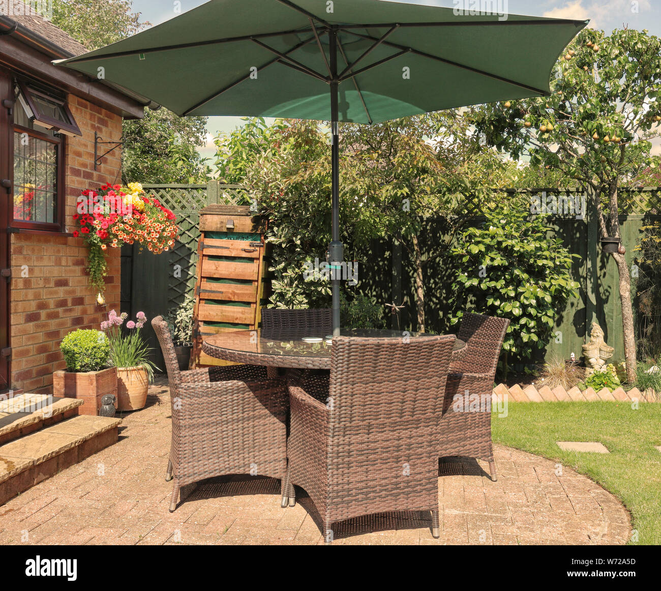 Inglés volver patio jardín con mesa, sillas y sombrilla Fotografía de stock  - Alamy