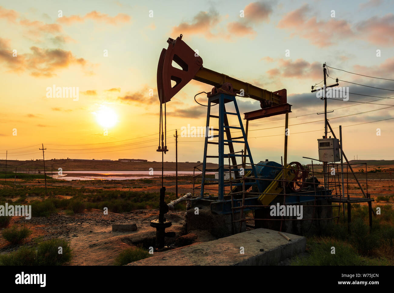 Oil Rig bomba contra un colorido atardecer cielo Foto de stock
