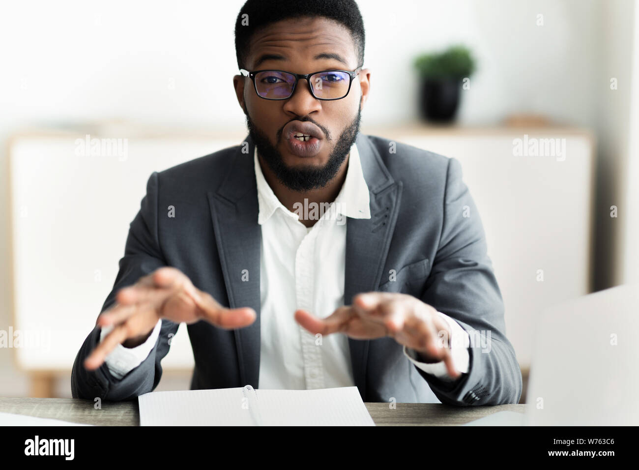 Retrato de guapo empresario busca en la cámara y hablar Foto de stock