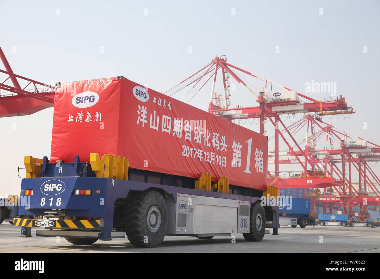Vehículos de guiado automático (AGV) de Shanghai International Port Group (SIPG) transporta un recipiente para ser enviados al extranjero en un muelle en el cuarto pha Foto de stock